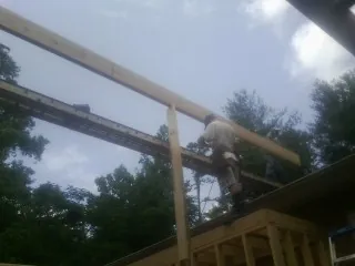 Carpenter setting a ridge beam over a new addition frame — Ice Dam Removal by Roofing Brothers in Manzanola