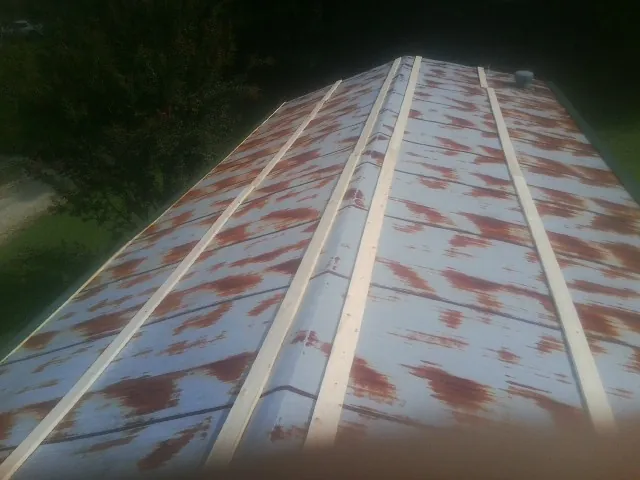 Rusted metal roof panels with new wood purlins before replacement — Storm Damage Roof Repair in Manzanola by Roofing Brothers