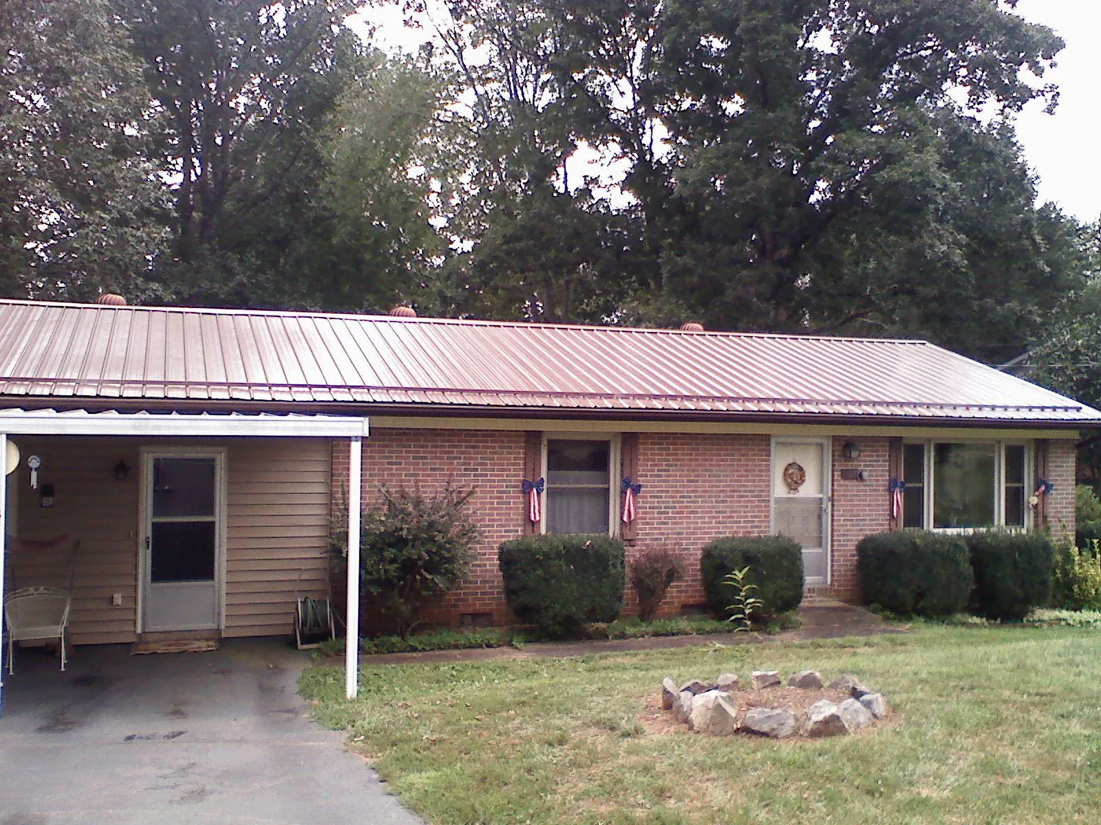 Bronze metal roof and carport on a brick ranch home — Roof Repair work by our crew in Manzanola